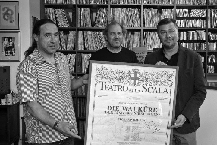 René Pape stellte drei Plakate von Aufführungen in der Mailänder Scala mit den Unterschriften der Künstler für eine Versteigerung für die Flutopfer zum Elbhangfest zur Verfügung. Eines ersteigerte für 1.300 Euro der „Sweetwater Recordstore“ in Loschwitz. René Pape (rechts) übergab das Plakat Tino Tuch persönlich, bei dem es jetzt zentral im Laden hängen wird. Götz Wenzel (links), Schatzmeister des Elbhangfest e.V., konnte das Geld in Empfang nehmen. Foto: Jürgen Frohse
