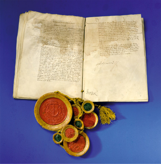 Augsburger Religionsfrieden, 25. September 1555 Pergamentlibell, acht Siegel an schwarz-gelben Seidenschnüren, Höhe 56 cm, Breite 35 cm Siegel: DM 1) 16 cm, 2) 5 cm, 3) 11 cm, 4) 6 cm, 5) 5,5 cm 6) 8 cm, 7) 7 cm Foto: Österreichisches Staatsarchiv, Haus-, Hof- und Staatsarchiv Wien, zur Verfügung gestellt von den Staatlichen Kunstsammlungen Dresden
