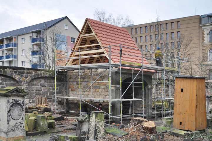 An der westlichen Mauer des Eliasfriedhofes ist quasi „aus Ruinen auferstanden“ die vormalige Güntz-Gruft. Sie war ehemals Bestandteil einer ganzen Grufthausreihe. – Im Vordergrund rechts ist die „Wintersicherung“ eines wertvollen Grabdenkmals zu sehen, im Hintergrund ist der neue Anbau des Landgerichtes Lothringer Straße erkennbar. Foto: Matthias Voigt (Ingenieurbüro)